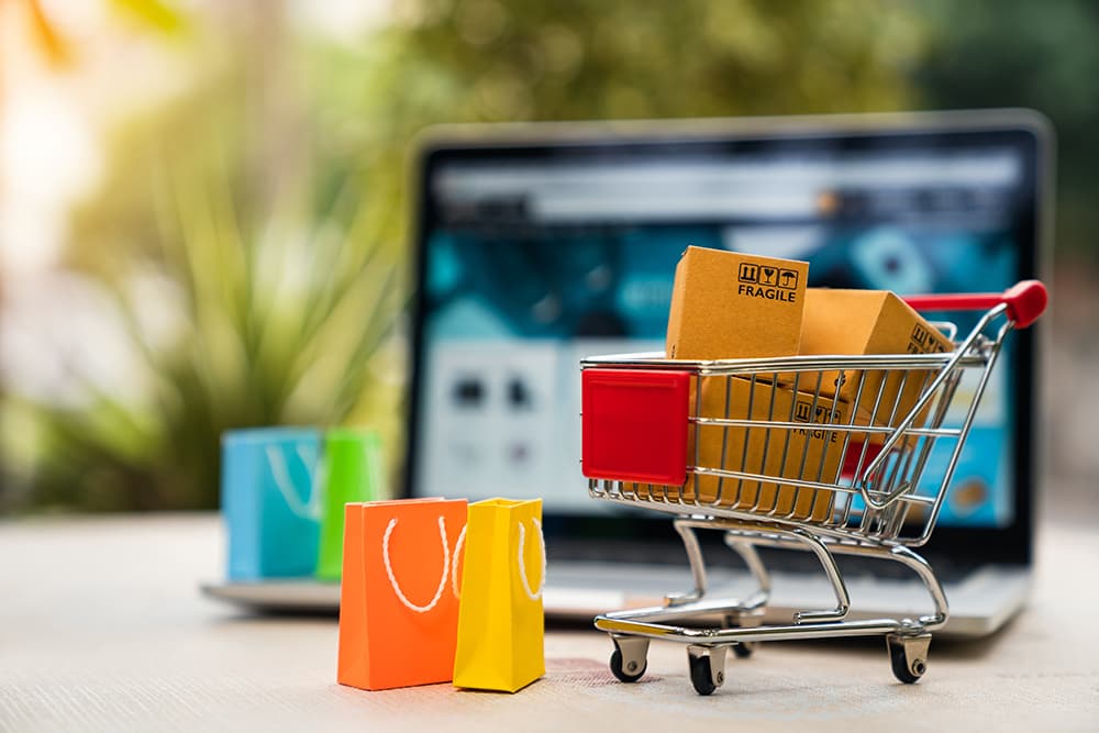 Ecommerce cart with laptop screen in background